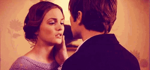 a man in a suit touches a woman 's face