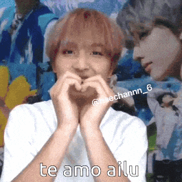 a young man is making a heart with his hands and says te amo ailu .
