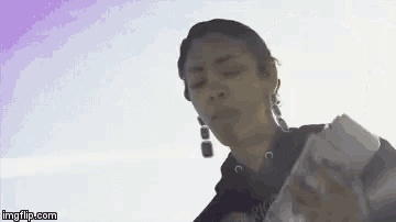 a woman is holding a piece of paper in her hand and eating it .