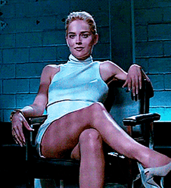 a woman sits in a chair with her legs crossed