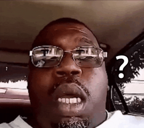 a man wearing glasses and a beard has a question mark above his head