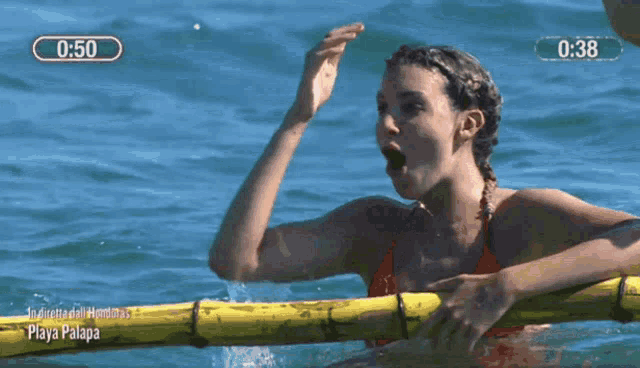 a woman in a red bikini is swimming in the ocean with a timer of 0:38