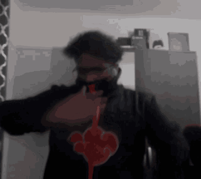 a blurry picture of a man wearing a black jacket with a red cloud on it