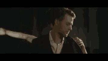 a man in a suit is dancing with a woman .