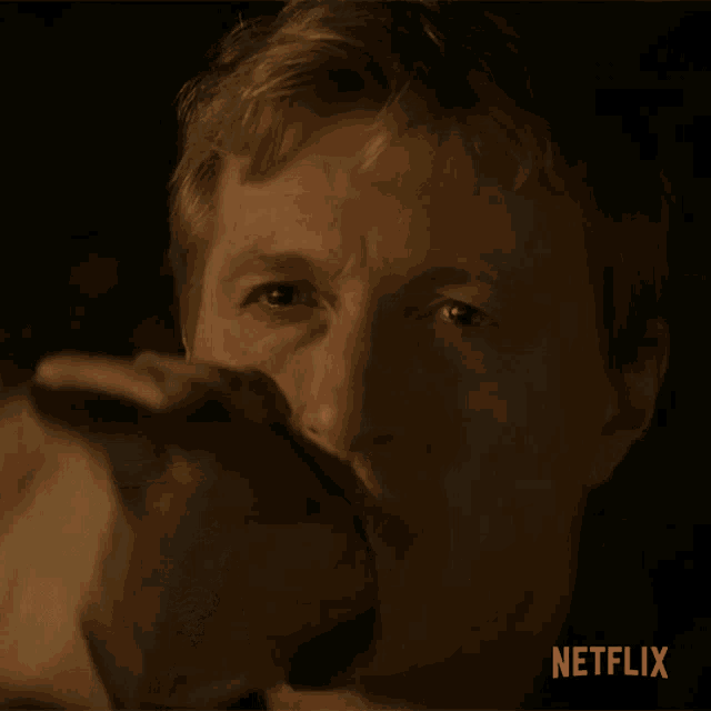 a close up of a man drinking from a glass with a netflix logo in the corner