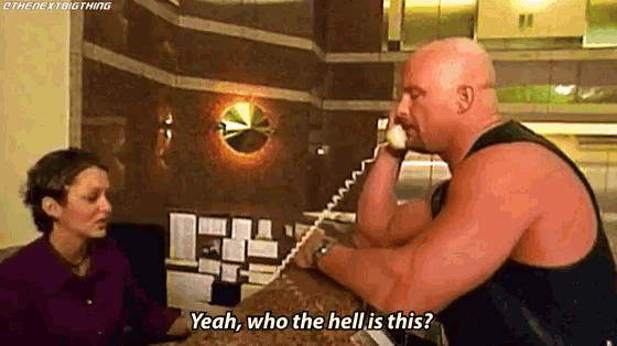 a bald man is talking on a telephone while a woman watches .