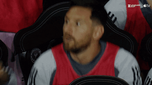 a man sitting in a stadium watching a leagues cup match