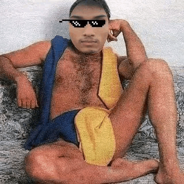 a man is sitting on a couch wearing sunglasses and a tie .