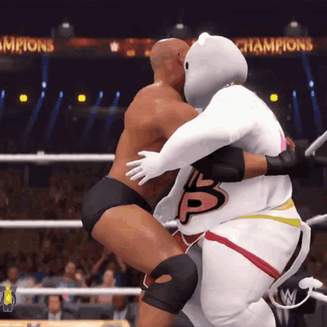 two wrestlers are hugging in a ring with champions written on the walls behind them