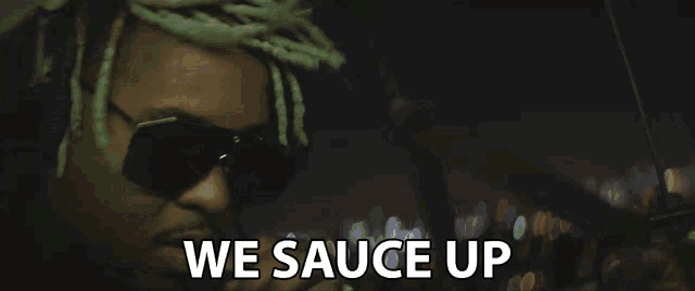 a man singing into a microphone with the words " we sauce up " above him