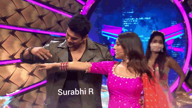 a man and a woman are dancing on a stage and the name surabhi r is on the bottom