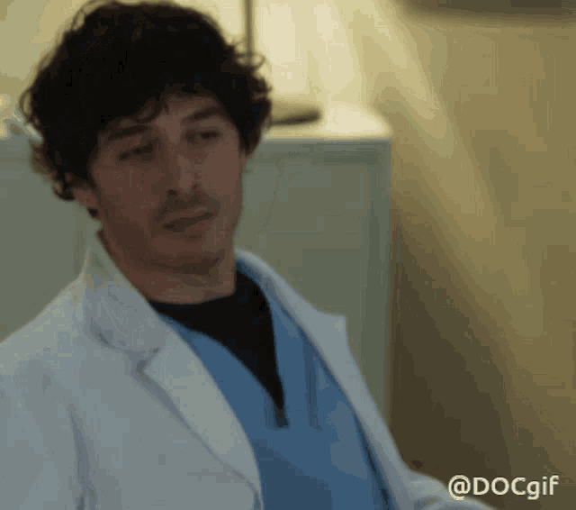 a man in a lab coat and scrubs has the hashtag docgif on the bottom right