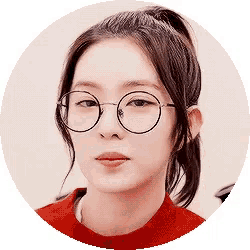 a woman wearing glasses and a red sweater is looking at the camera .