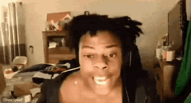 a man with dreadlocks is wearing headphones and making a face .