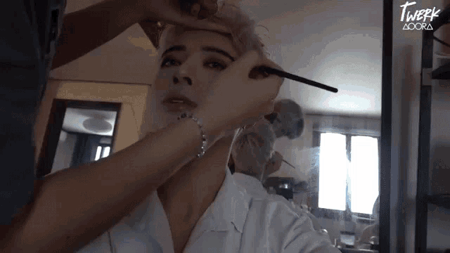 a woman is getting her eyebrows painted by a makeup artist called twerk adora