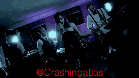 a woman with purple hair singing into a microphone with the words @crashingatlas in red