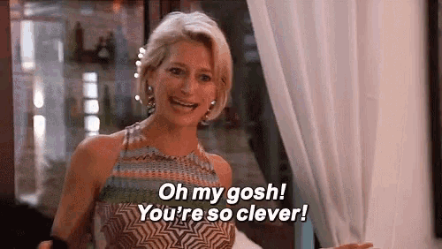 a woman is standing in front of a window and saying `` oh my gosh ! you 're so clever ! ``