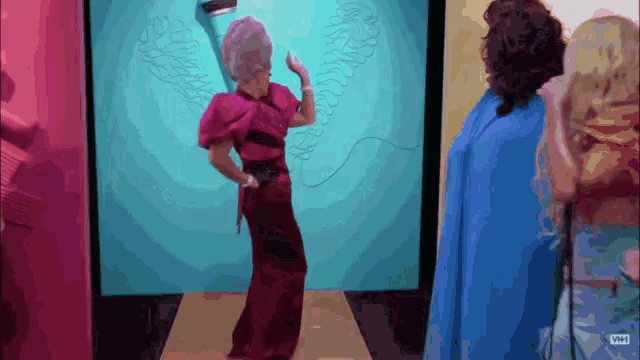 a woman in a red dress is dancing in front of a screen that says vh1