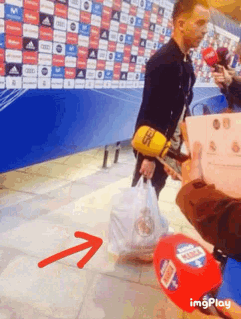 a red arrow points to a person carrying a bag that says ' ss ' on it