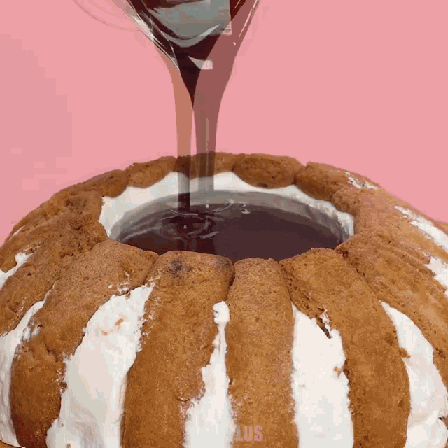a cake with a hole in the middle is being poured with chocolate sauce