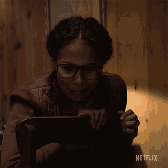 a woman sitting in a chair with a netflix logo on the bottom