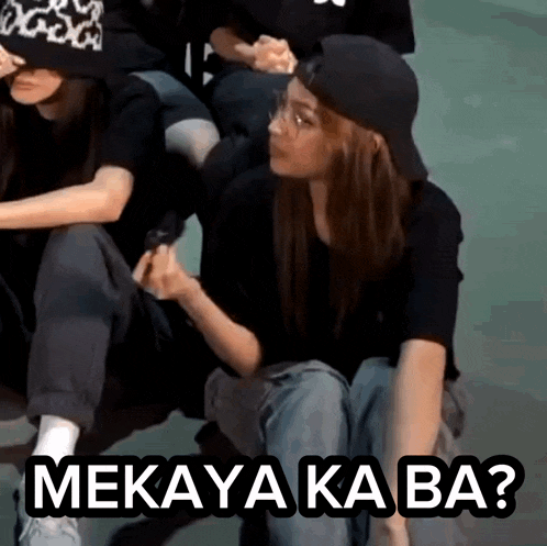 a woman wearing a baseball cap is sitting next to a group of people with the words mekaya ka ba written above her