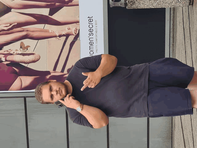 a man is standing in front of a women 's secret sign