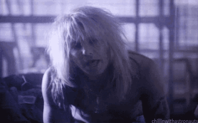 a woman with blonde hair is laying on a bed with the words chillinwithastronauts below her