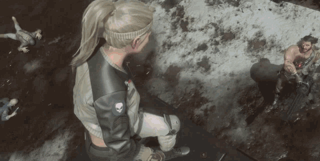 a woman in a leather jacket with a skull on the back sits in the dirt surrounded by people