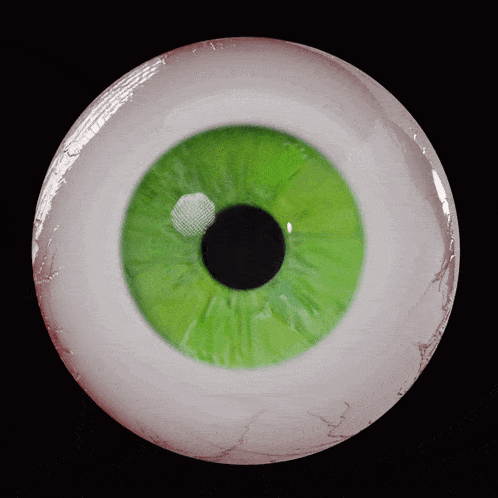 a close up of a green eye with a red pupil
