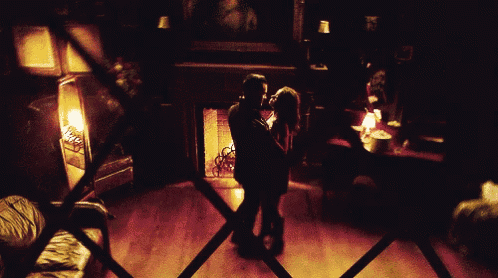 a man and woman are dancing in a dark room