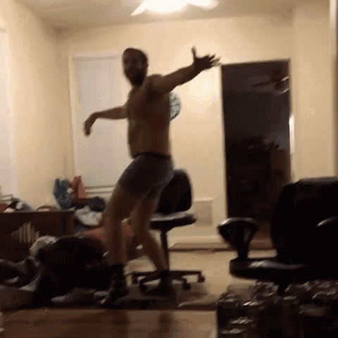 a man without a shirt is dancing in a room