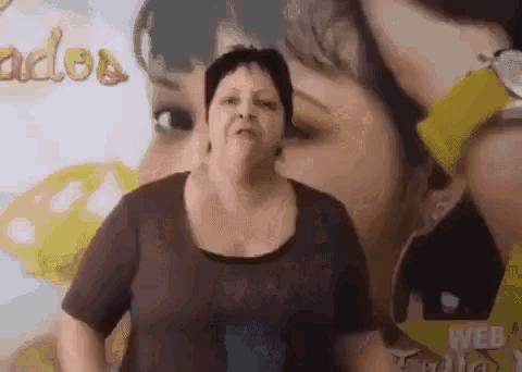 a woman is standing in front of a sign that says ' carlos ' on it .