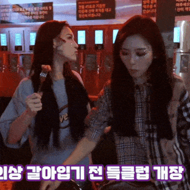 two women are standing next to each other in front of signs that say antimonster