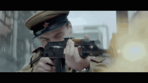a man in a military uniform is holding a gun
