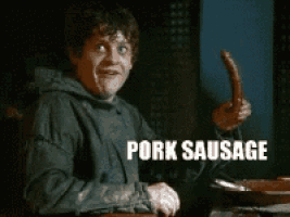 a man holding a sausage with the word pork sausage written on it