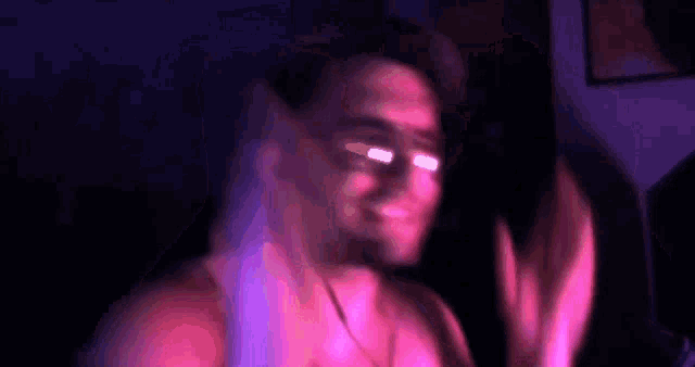 a man without a shirt is blowing bubbles in a pink and purple room .
