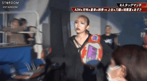 a woman stands in front of a sign that says stardom in red
