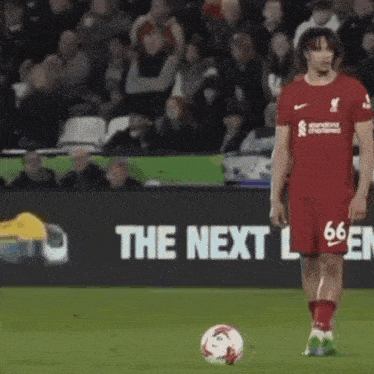 a soccer player kicks a ball in front of a sign that says the next league