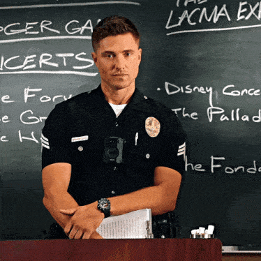 a police officer stands at a podium in front of a blackboard that says lacma