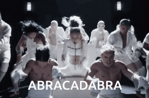 a group of people are dancing and the word abracadabra is on the bottom right