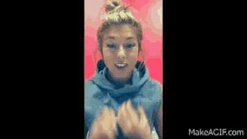 a woman in a blue shirt is making a funny face