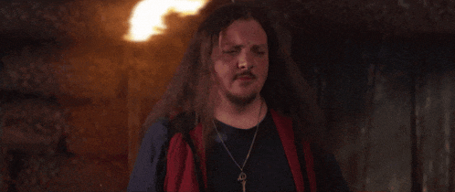 a man with long hair is holding a cowboy hat