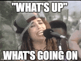 a woman is singing into a microphone with the words `` what 's up '' written on it .