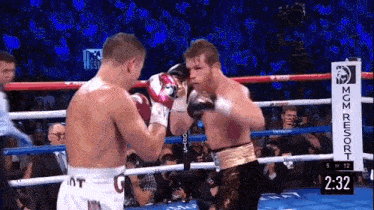 two boxers are fighting in a boxing ring with a sign that says mgm resort