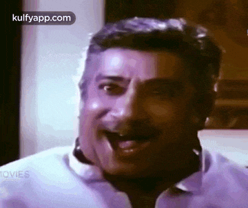 a man with a mustache is making a funny face with his tongue out .
