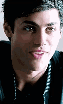 a close up of a young man 's face with his mouth open and his eyes looking at the camera .