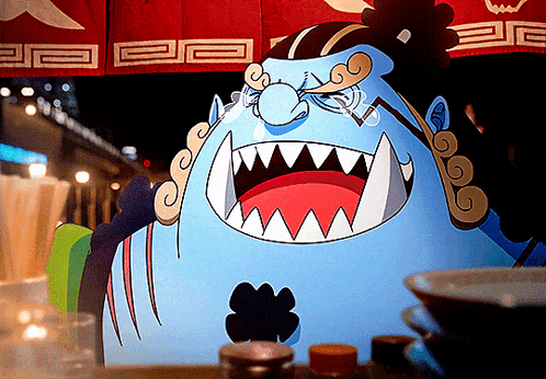 a cartoon character with a huge mouth and sharp teeth is sitting on a table