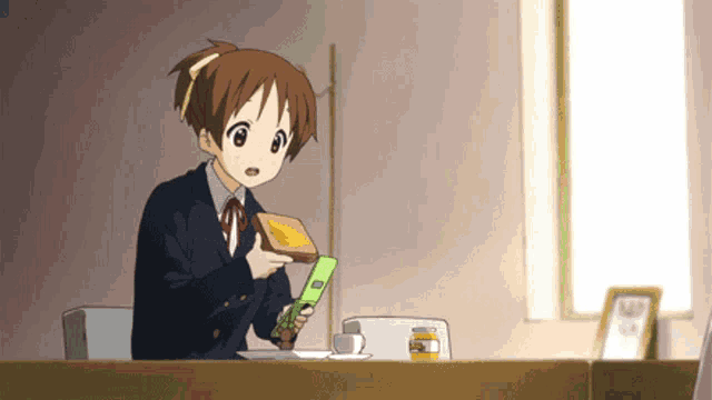 a girl in a school uniform is holding a piece of toast in her hands