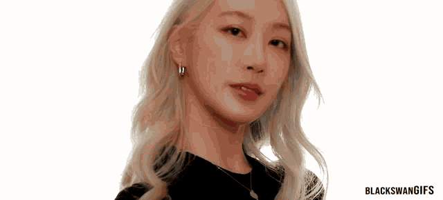 a woman with blonde hair is wearing a black shirt and earrings ..